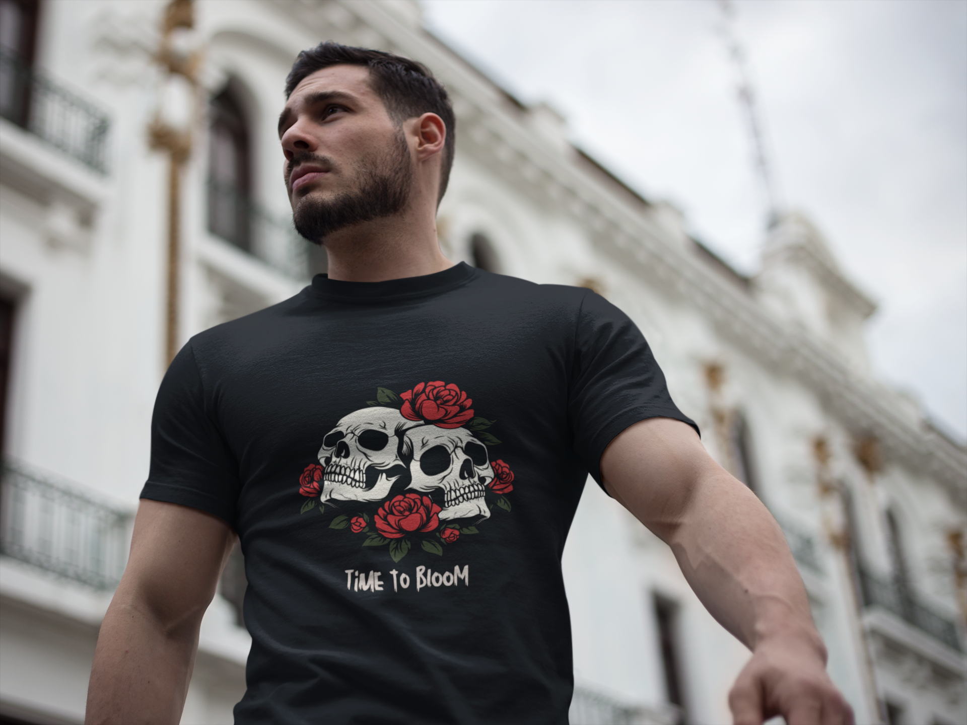 Man wearing a black t-shirt with skull and rose design in an urban setting
