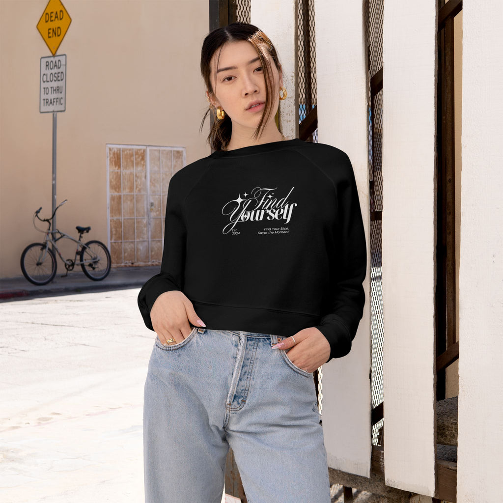 Person wearing a black sweatshirt with text, standing in an urban setting.