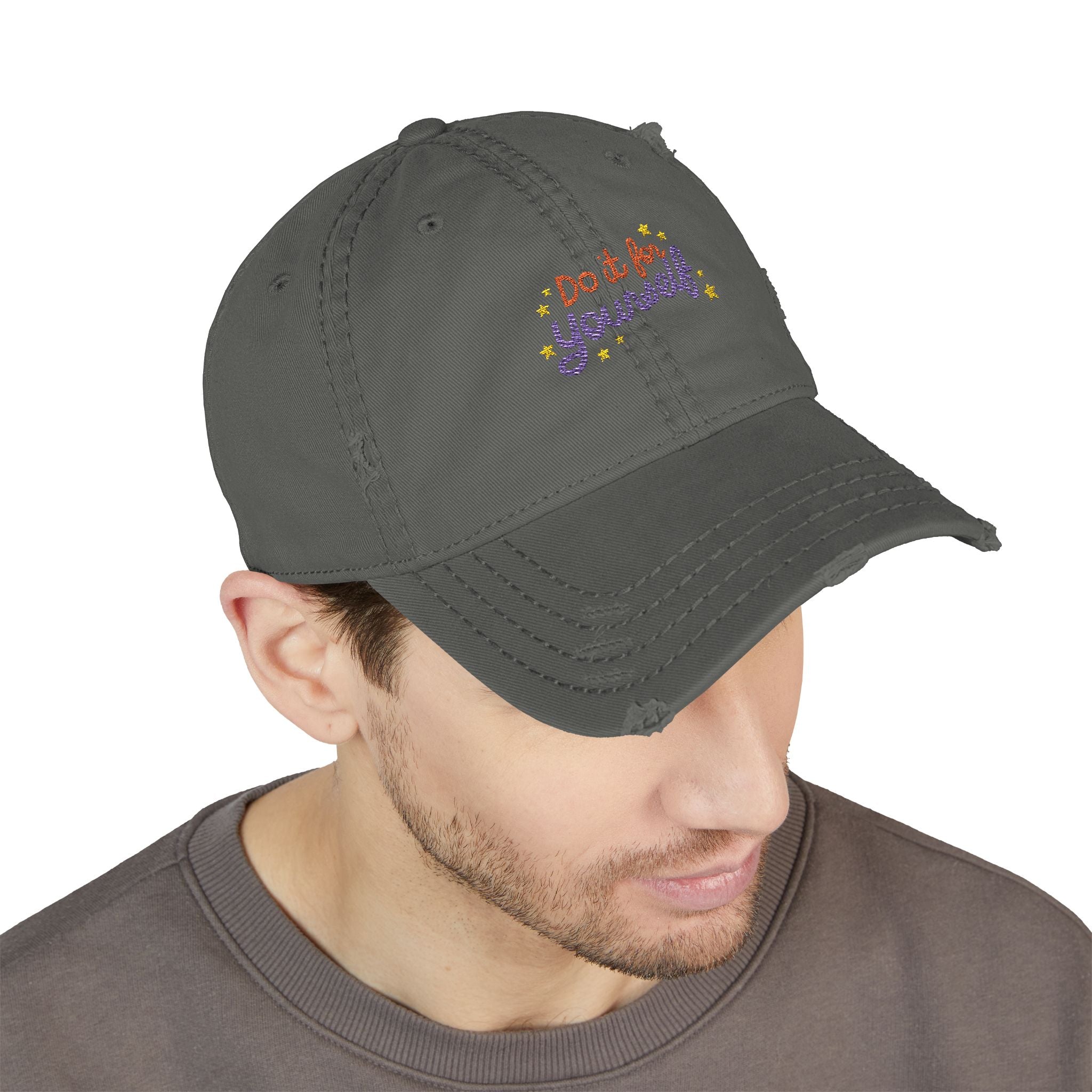 Man wearing a gray cap with colorful text on a white background
